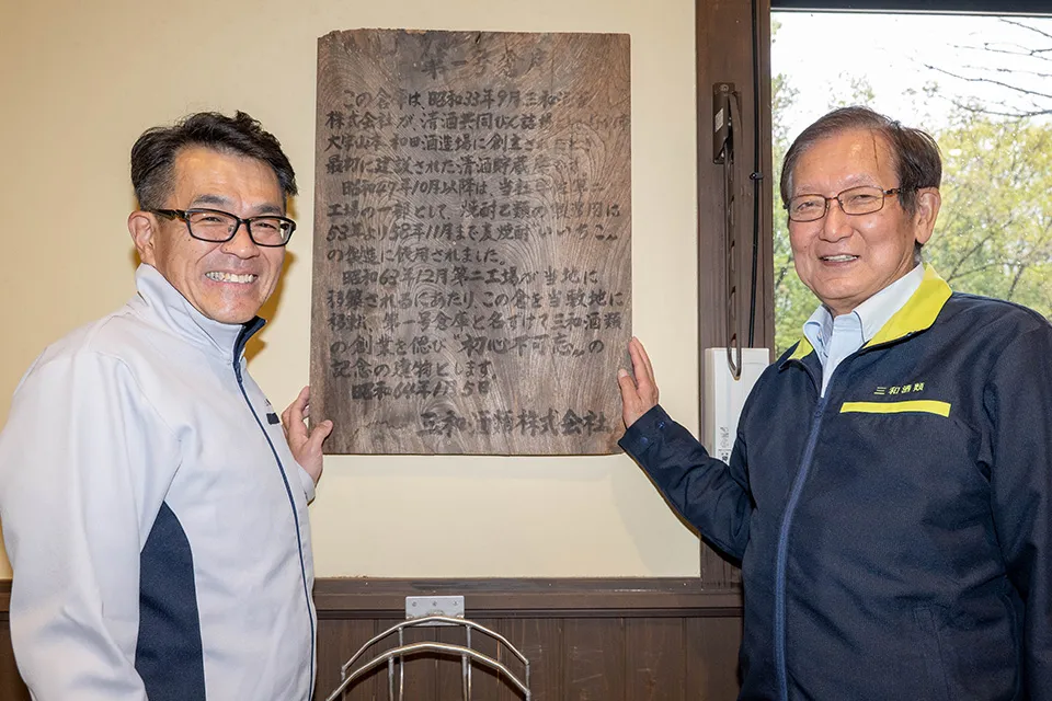 「壱號蔵」内の壁には建物の由来が木板に墨文字で書かれている。和田（右）と丸尾