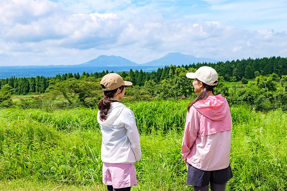 コース左手に見える阿蘇の山並み。「阿蘇山」は5つの山を中心とした連山や、外輪山、火口原を指す総称。写真左のノコギリ型のピークが根子岳（標高1433m）、その右が阿蘇五岳の最高点・高岳（標高1592m）