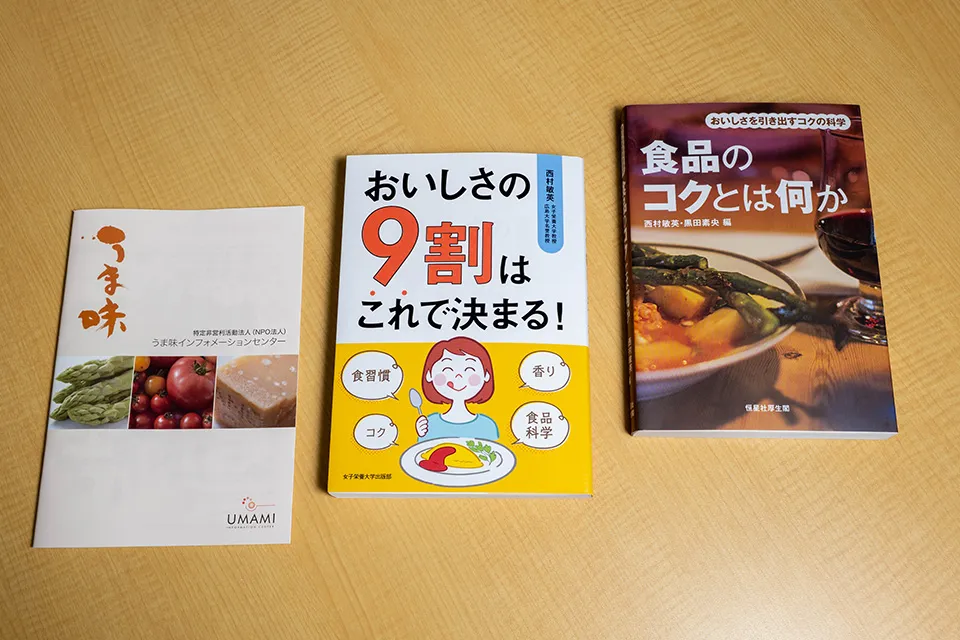 右から順に、西村先生の編著作「食品のコクとは何か」（恒星社厚生閣)、著作「おいしさの9割はこれで決まる!」（女子栄養大学出版部）、編集に関わった冊子「うま味」（うま味インフォメーションセンター）